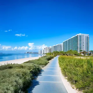Coastal path beside the beach with high-rise buildings in the distance