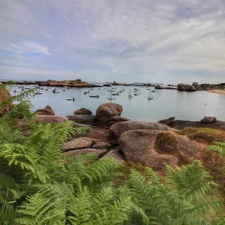 Rocky shoreline and moored boats on a calm bay